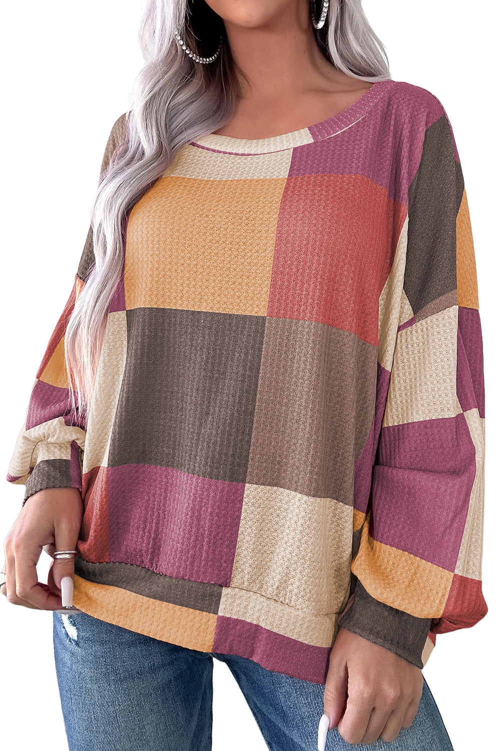 Person wearing a colorful checkered sweater with long sleeves.