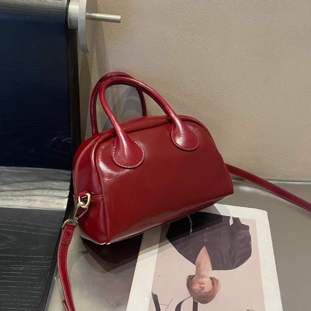 Red handbag on a magazine with a blurred background