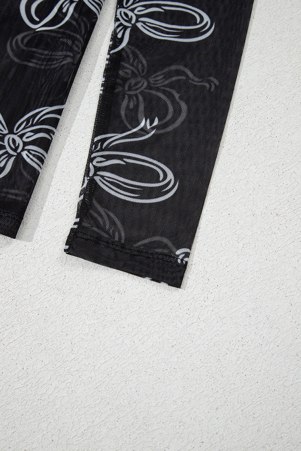 Black leggings with white floral patterns on a white background