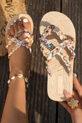 Beige sandals with colorful straps on a wooden surface