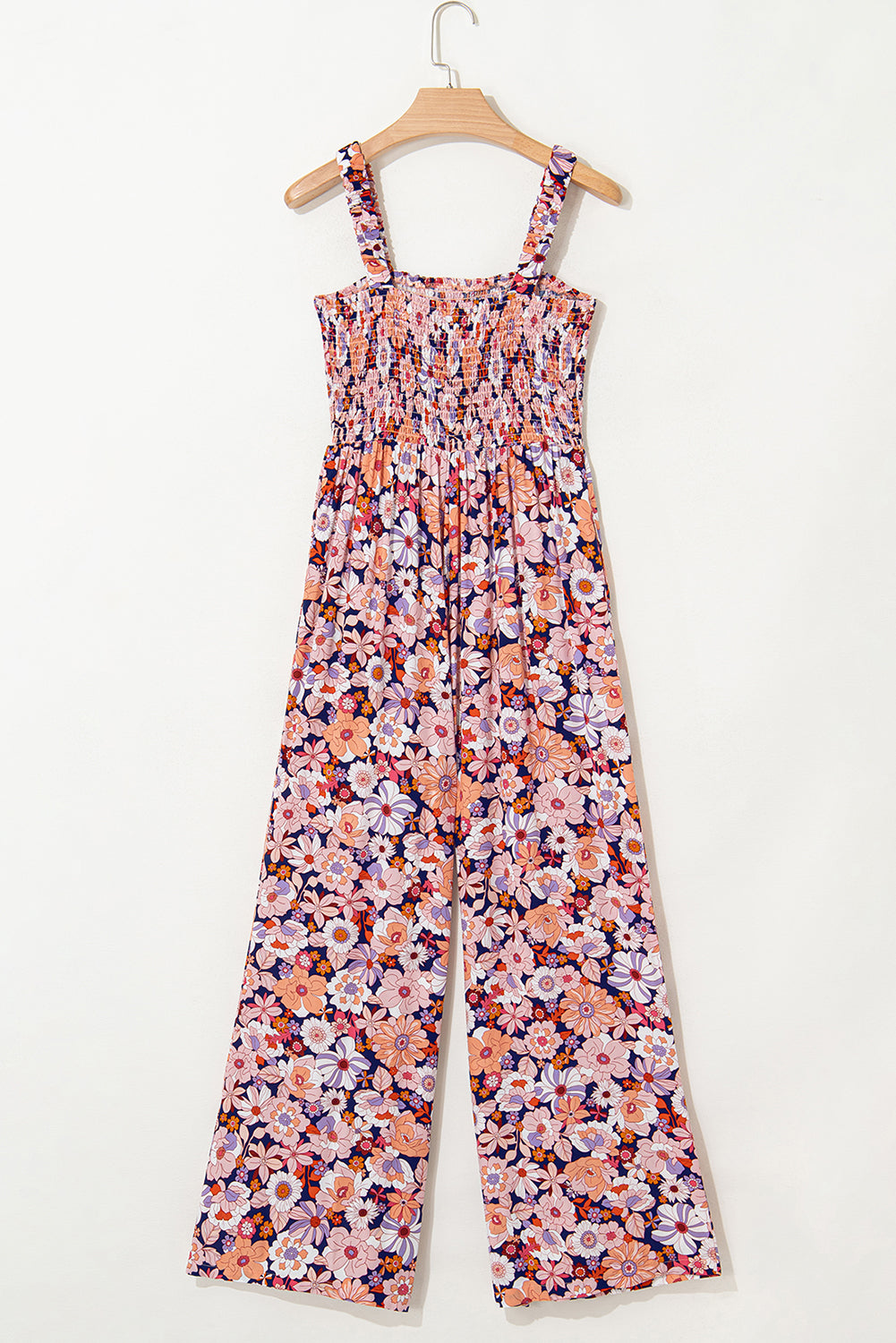 Floral jumpsuit on a hanger against a white background