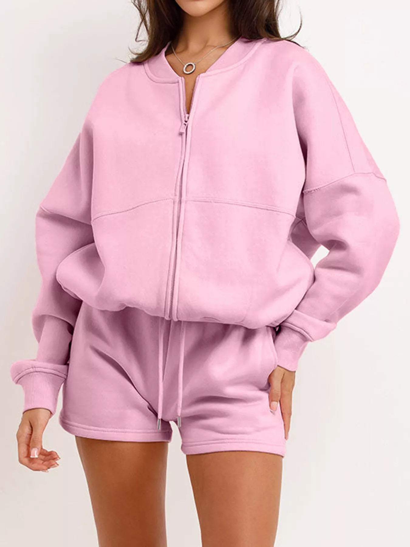 Pink zip-up hoodie and shorts set on a white background