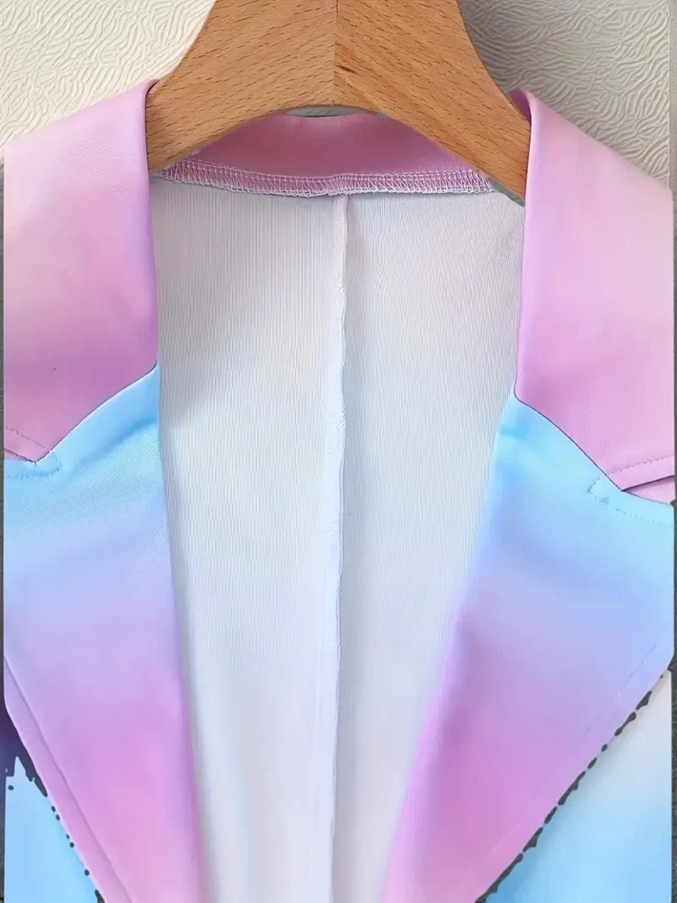 Pastel gradient top on a hanger against a neutral background