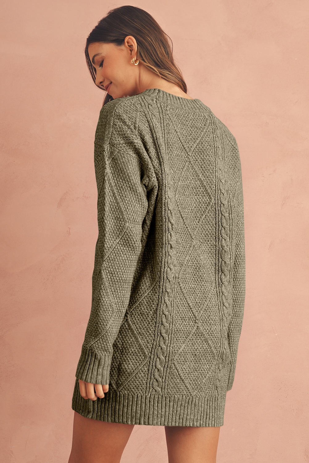 Woman wearing a green cable knit sweater dress back view