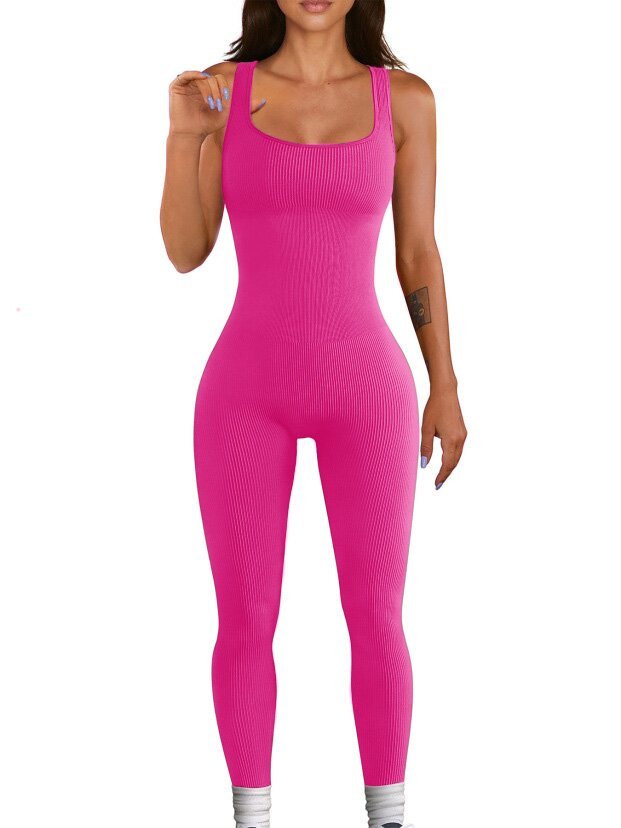 Person wearing a bright pink ribbed jumpsuit on a white background