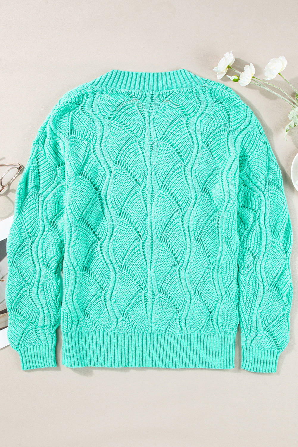 Green cable knit sweater on a light background