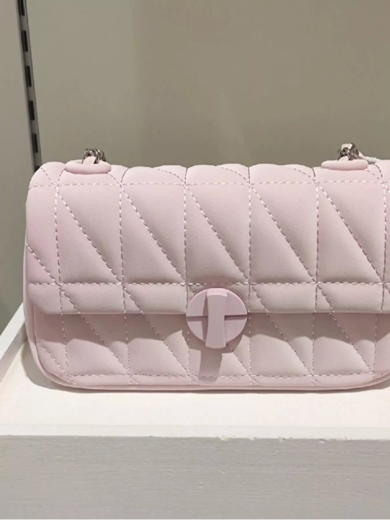 Quilted pink handbag on a light gray background