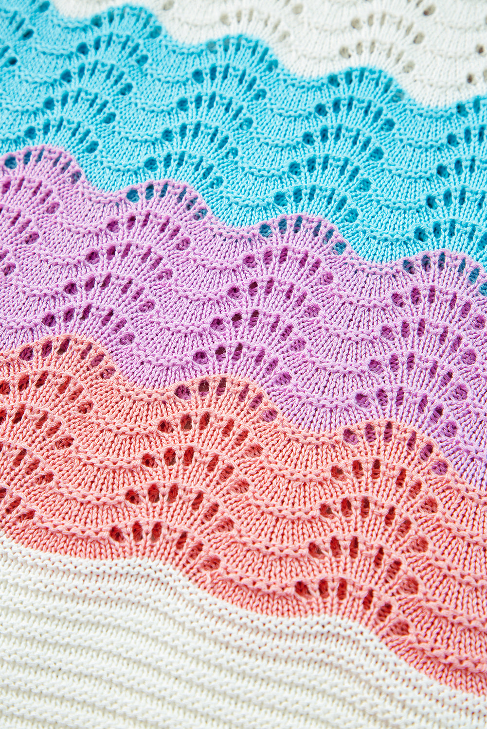 Close-up of colorful crocheted fabric with blue, pink, and red patterns.