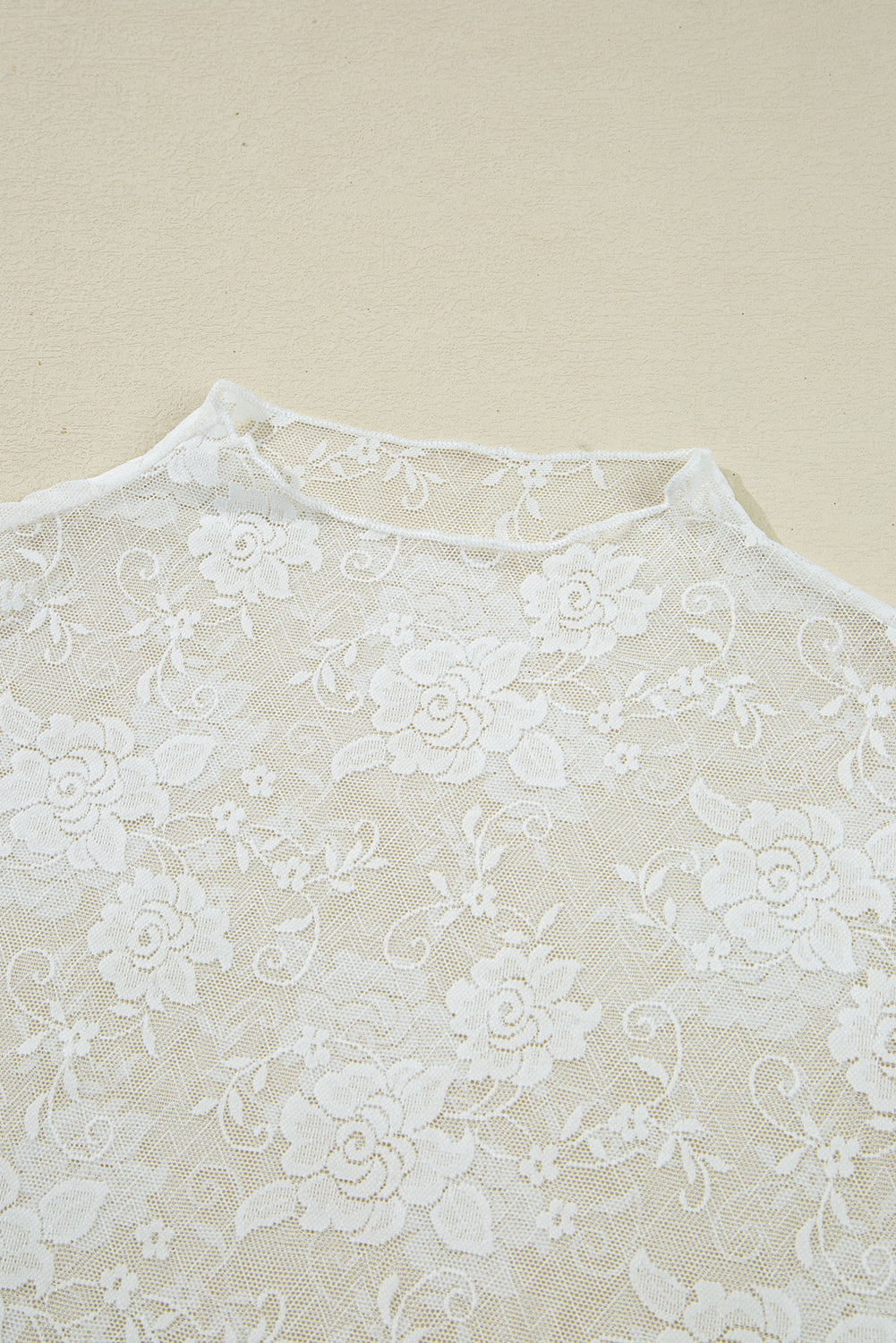 Close-up of white lace fabric on a beige background