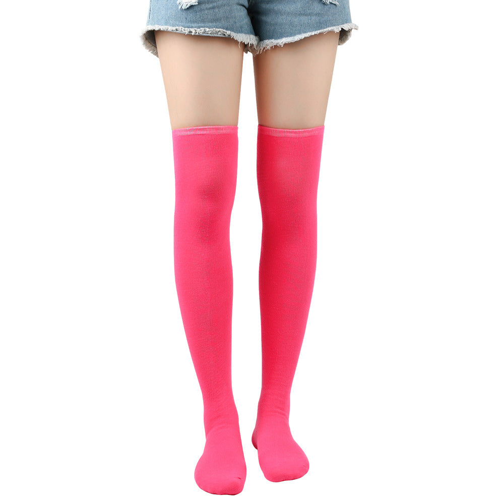 Pink knee-high socks worn with denim shorts on a white background