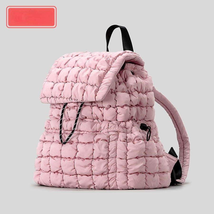 Pink quilted backpack on a light gray background