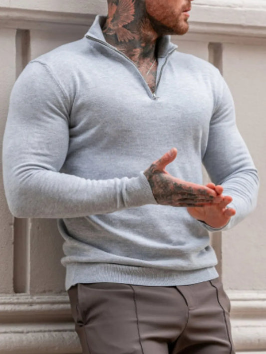 Man wearing a light gray quarter zip long sleeve knit top  