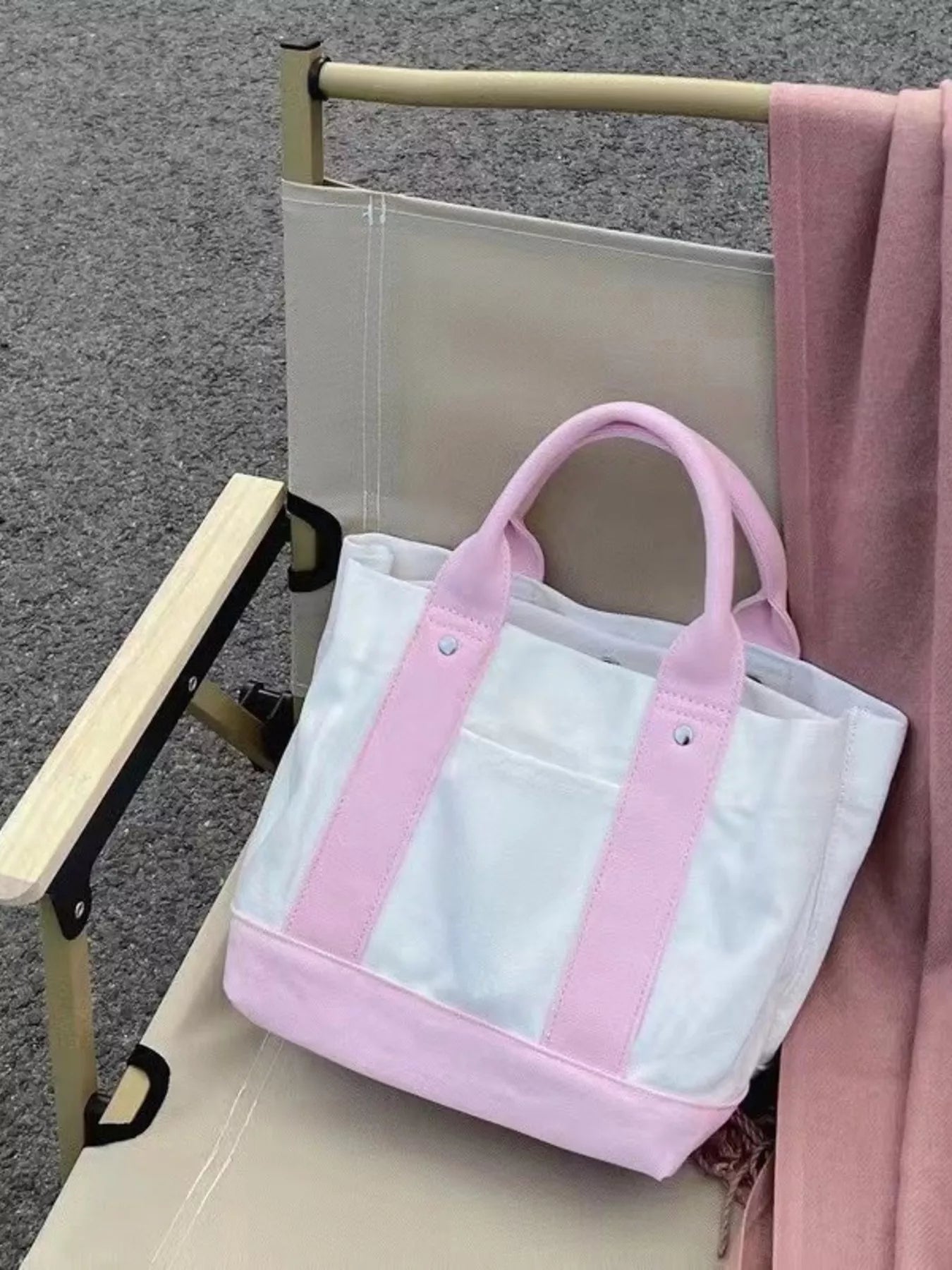 White tote bag with pink handles and trim on a chair