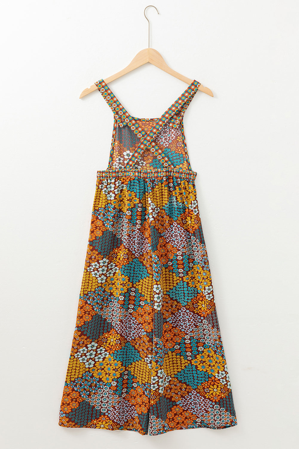 Colorful patterned dress on a hanger against a white background