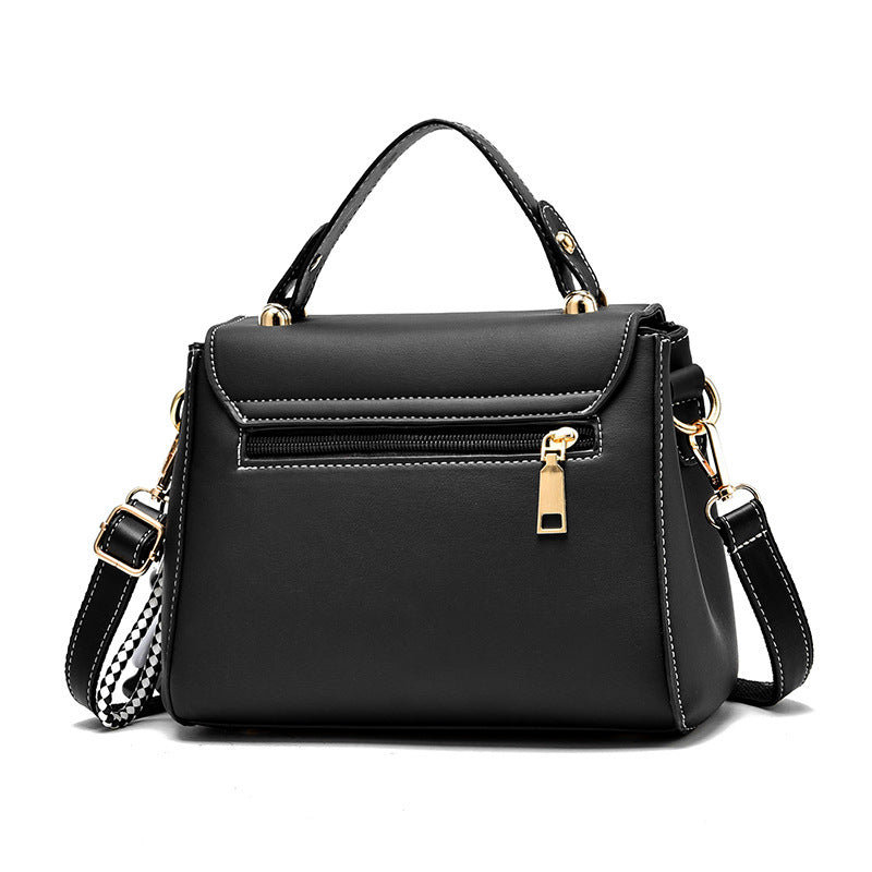 Black handbag with gold accents on a white background