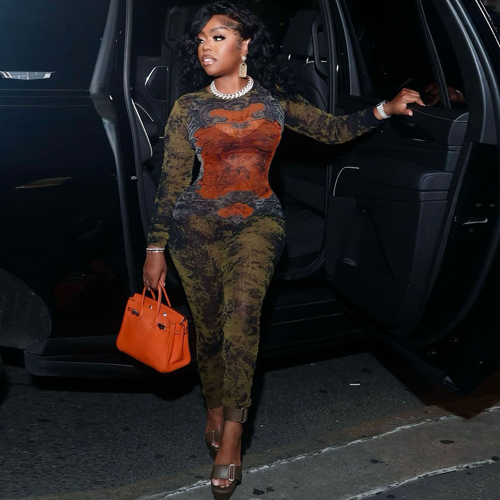 Woman in patterned outfit stepping out of a car with an orange handbag.