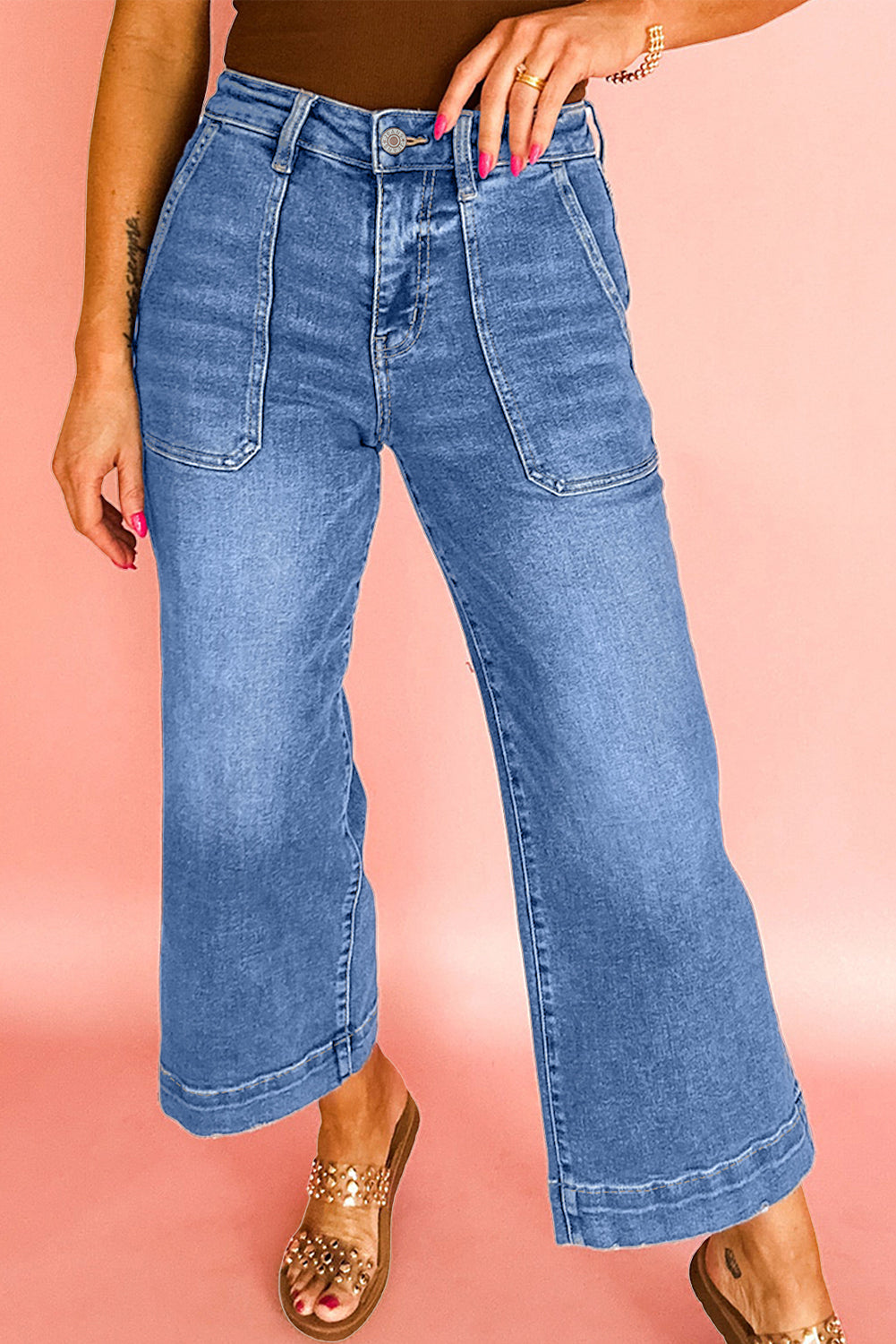 Person wearing blue jeans on a pink background