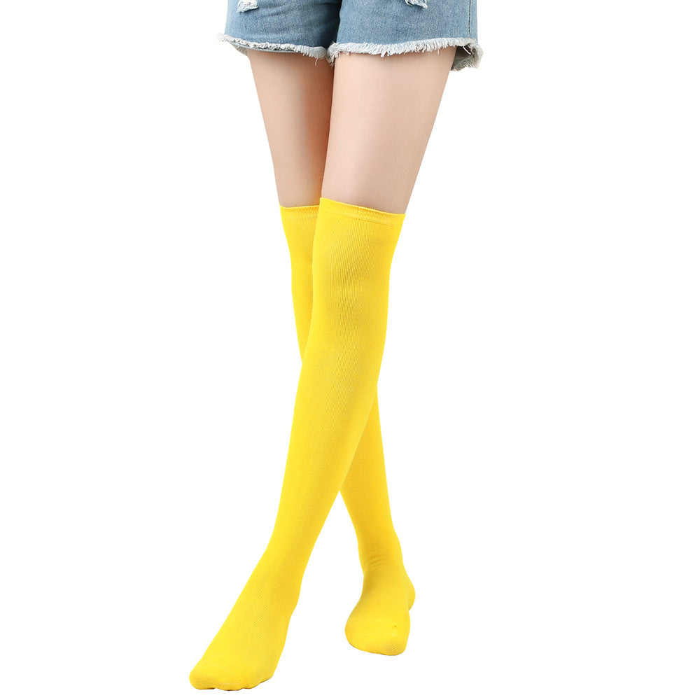 Yellow knee-high socks worn with denim shorts on a white background