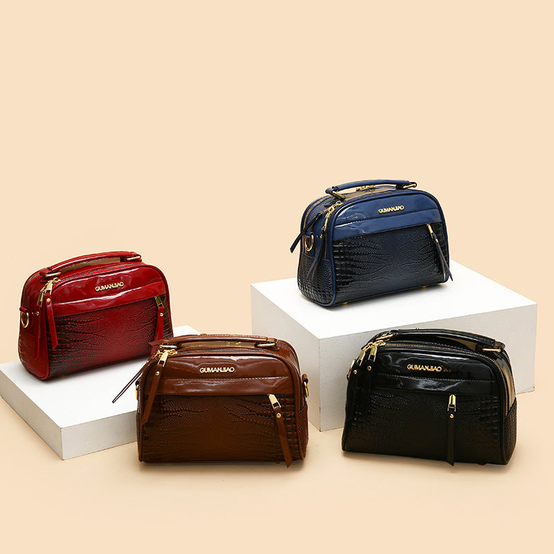 Four leather handbags in red, blue, brown, and black on a beige background