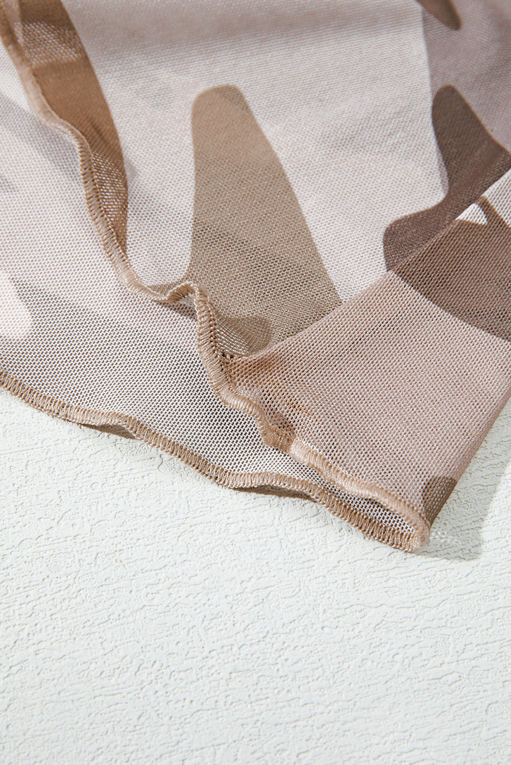 Close-up of beige and brown camouflage fabric on a white background