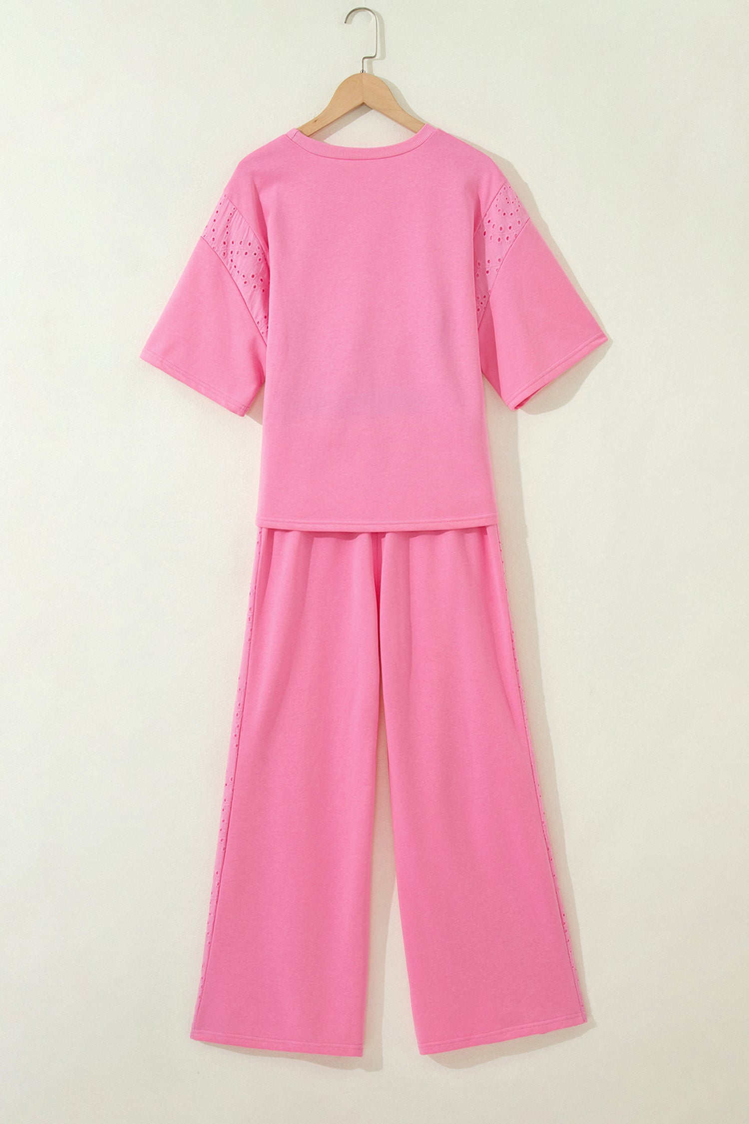 Pink outfit set on a hanger against a white background back view