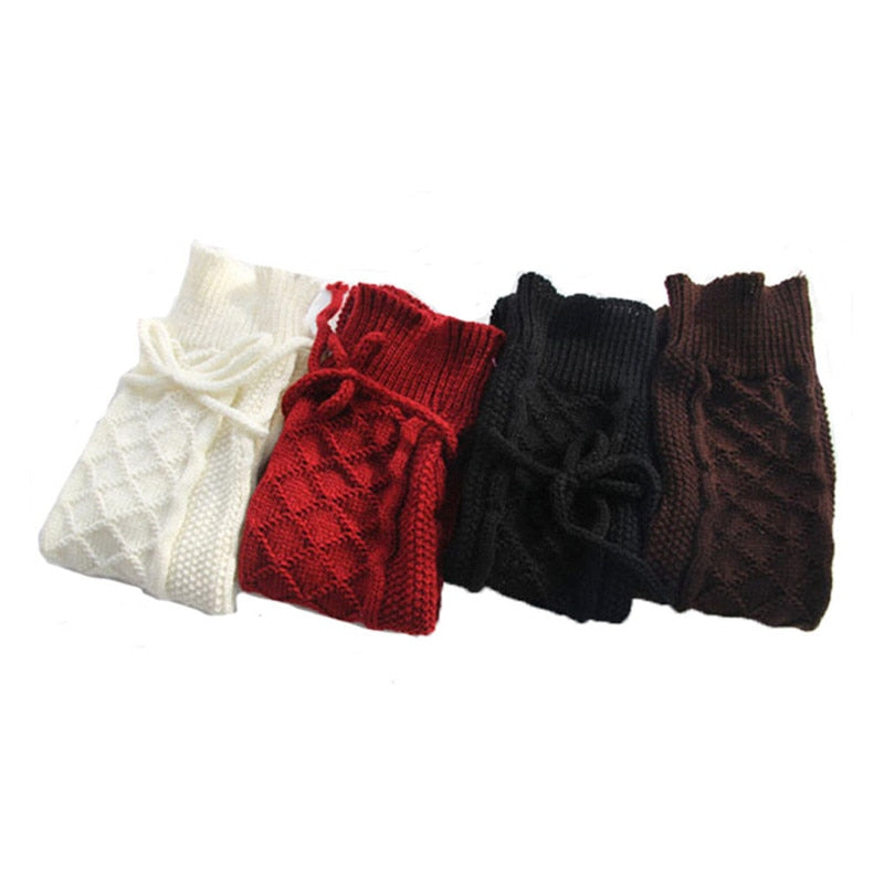 Four knitted arm warmers in white, red, black, and brown on a white background