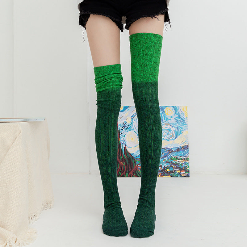 Green knee-high socks worn by a person with a painting in the background