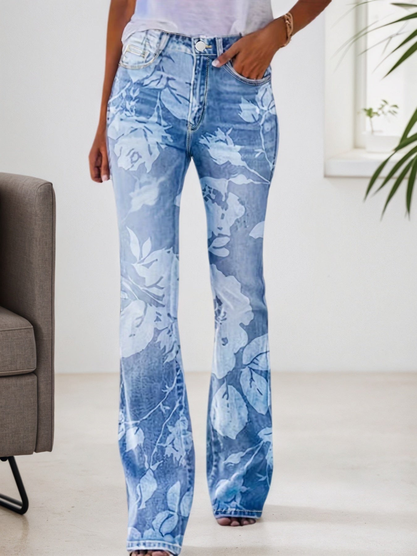 Person wearing blue floral jeans in a minimal indoor setting