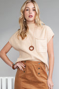 Woman wearing a beige sleeveless top with a pocket and brown skirt on a gray background