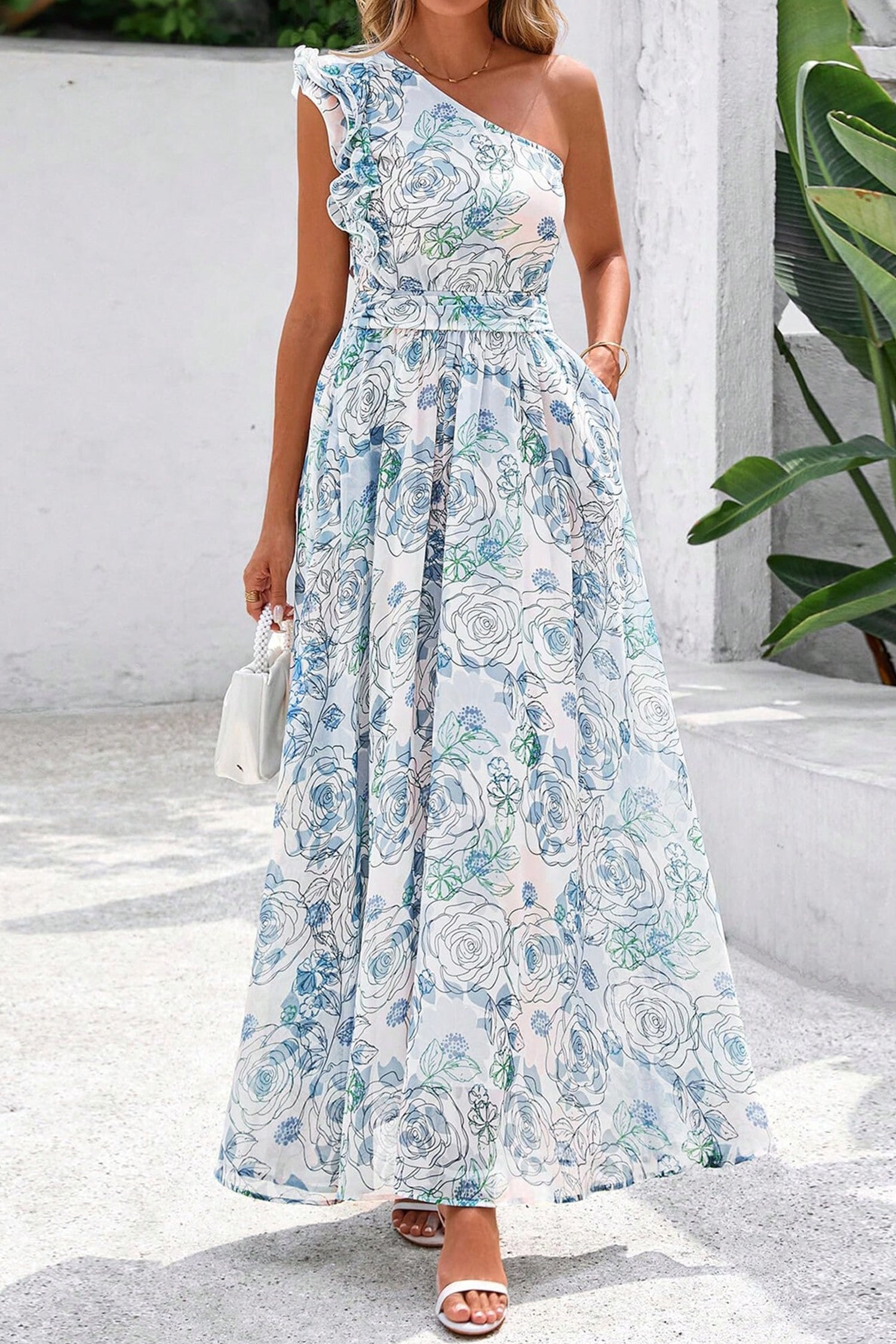Woman wearing a floral one-shoulder dress with a white background