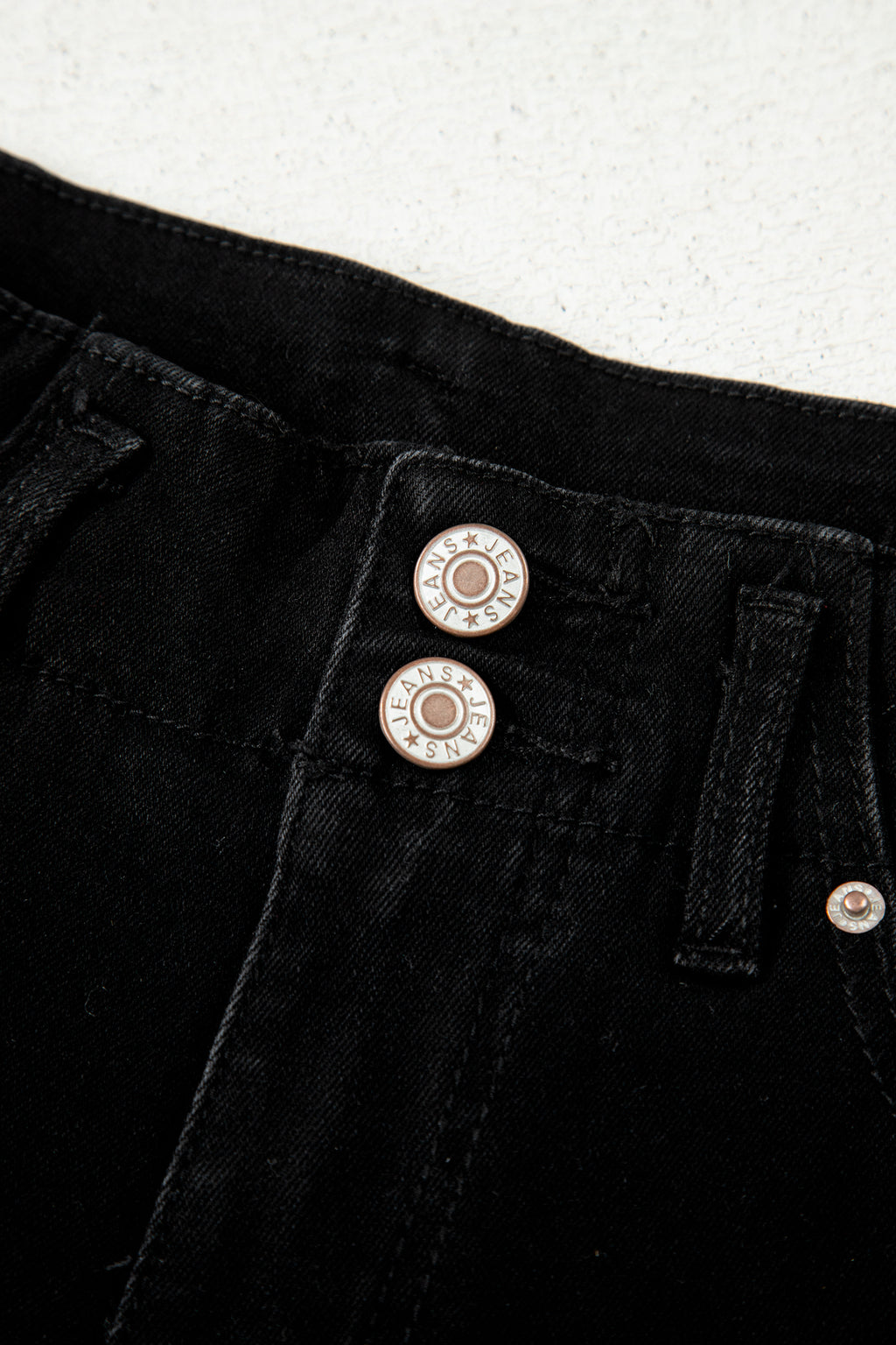 Close-up of black High Waist Wide Leg Jeans decorative front buttons 