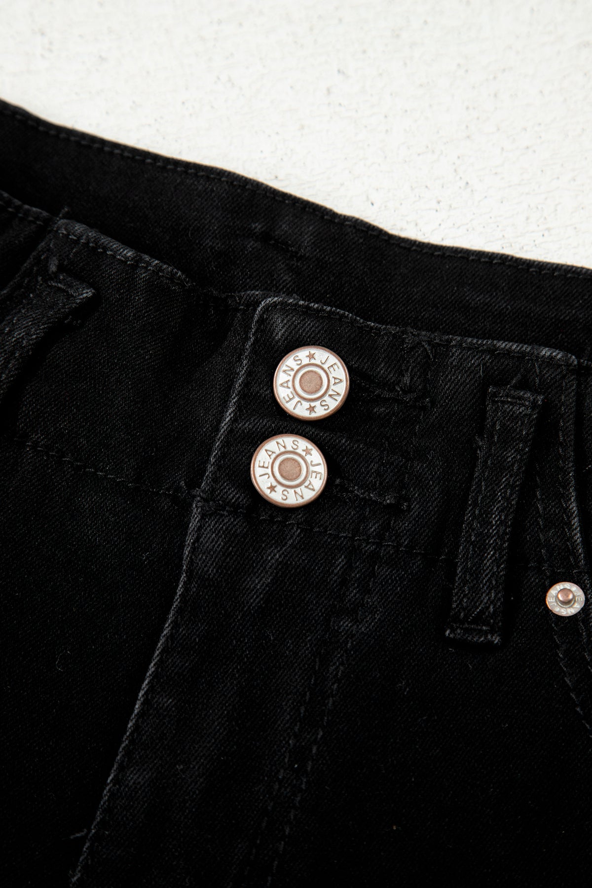 Close-up of black High Waist Wide Leg Jeans decorative front buttons 