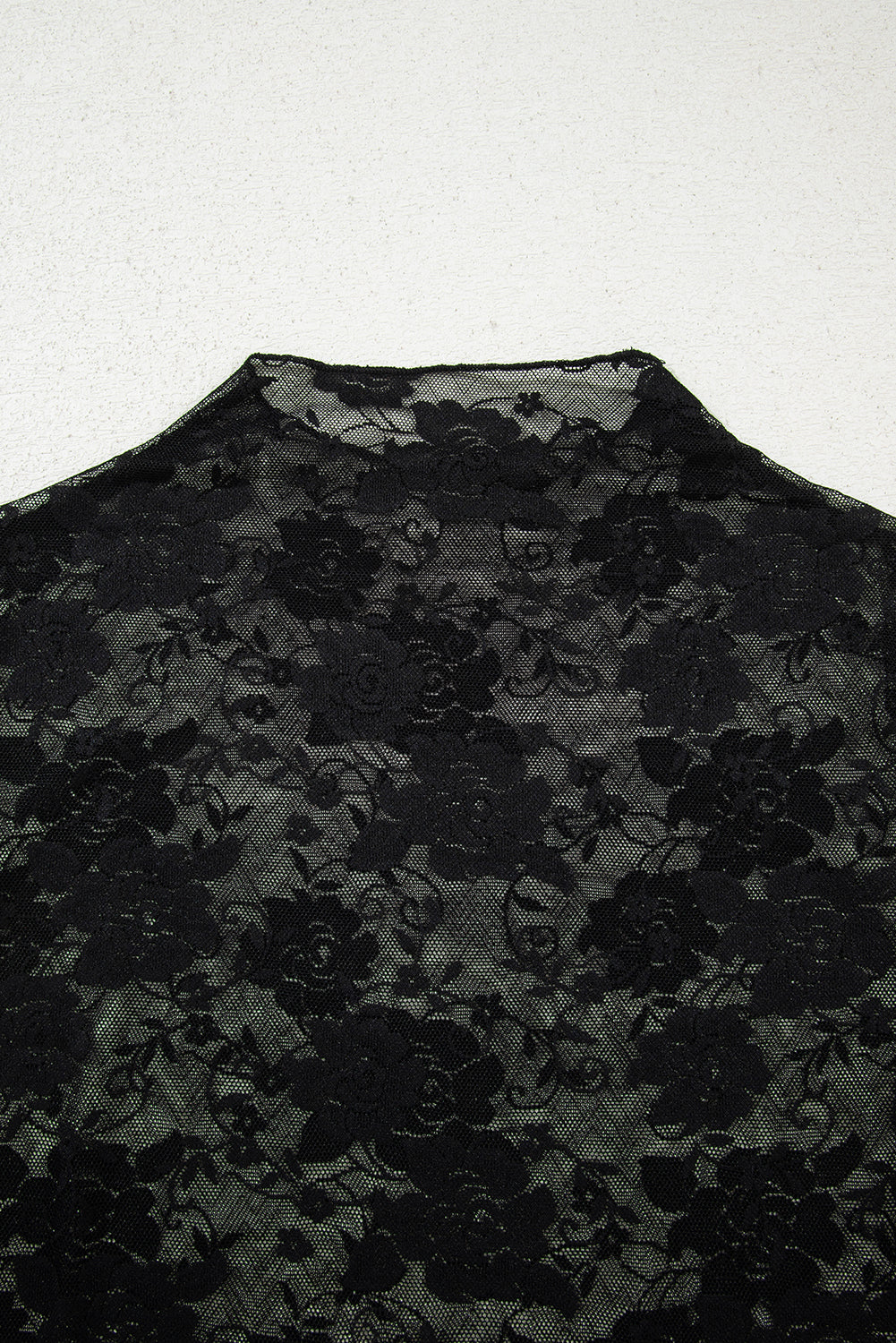 Black floral lace fabric on a white background