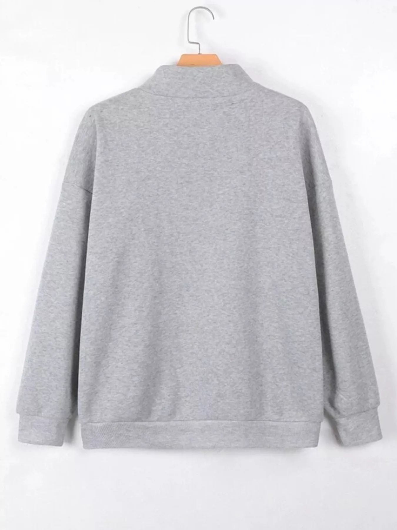 Gray sweatshirt on a hanger against a white background