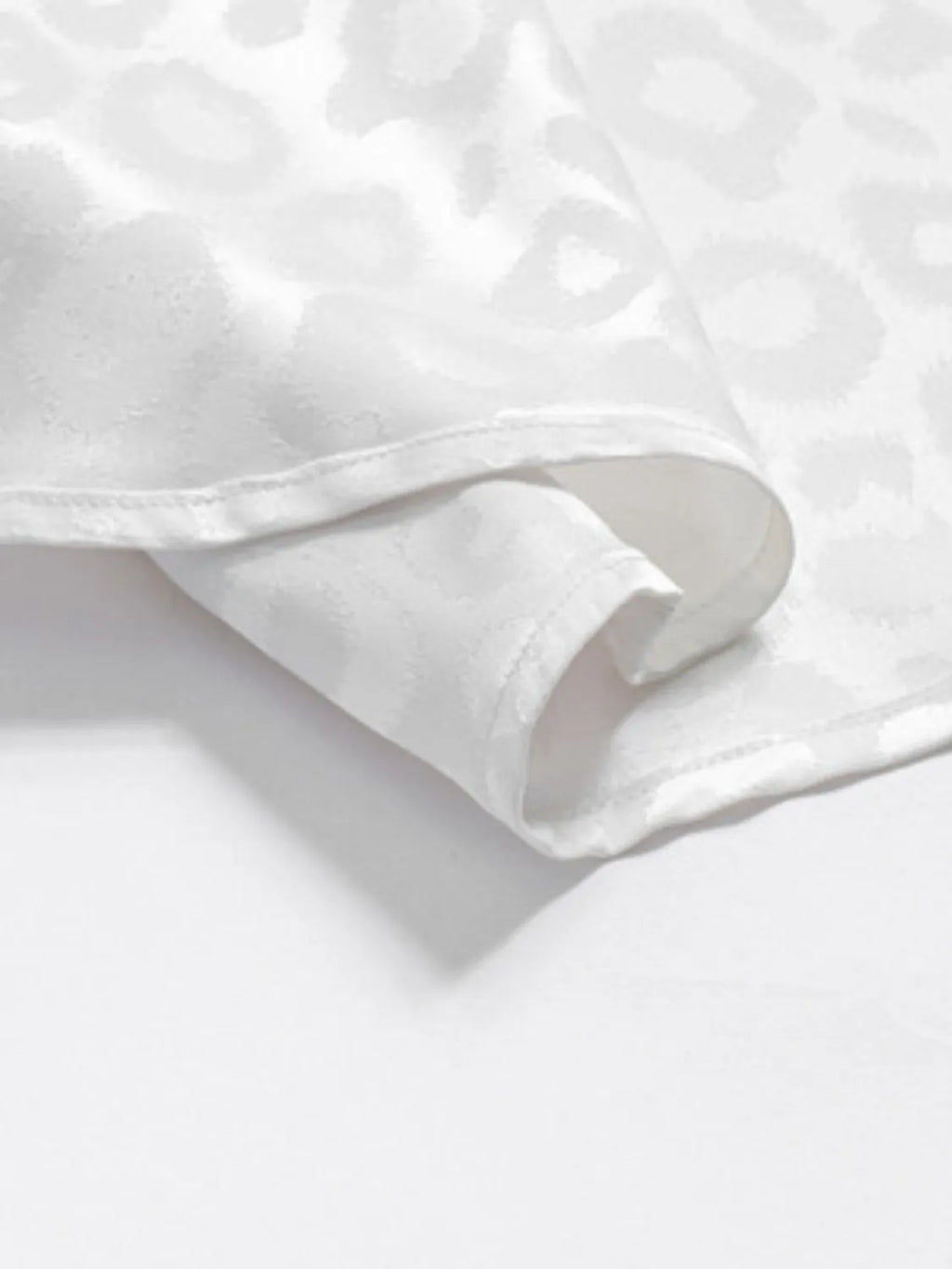 Detailed Close-up of a White Leopard pattern Button Down Satin Shirt  