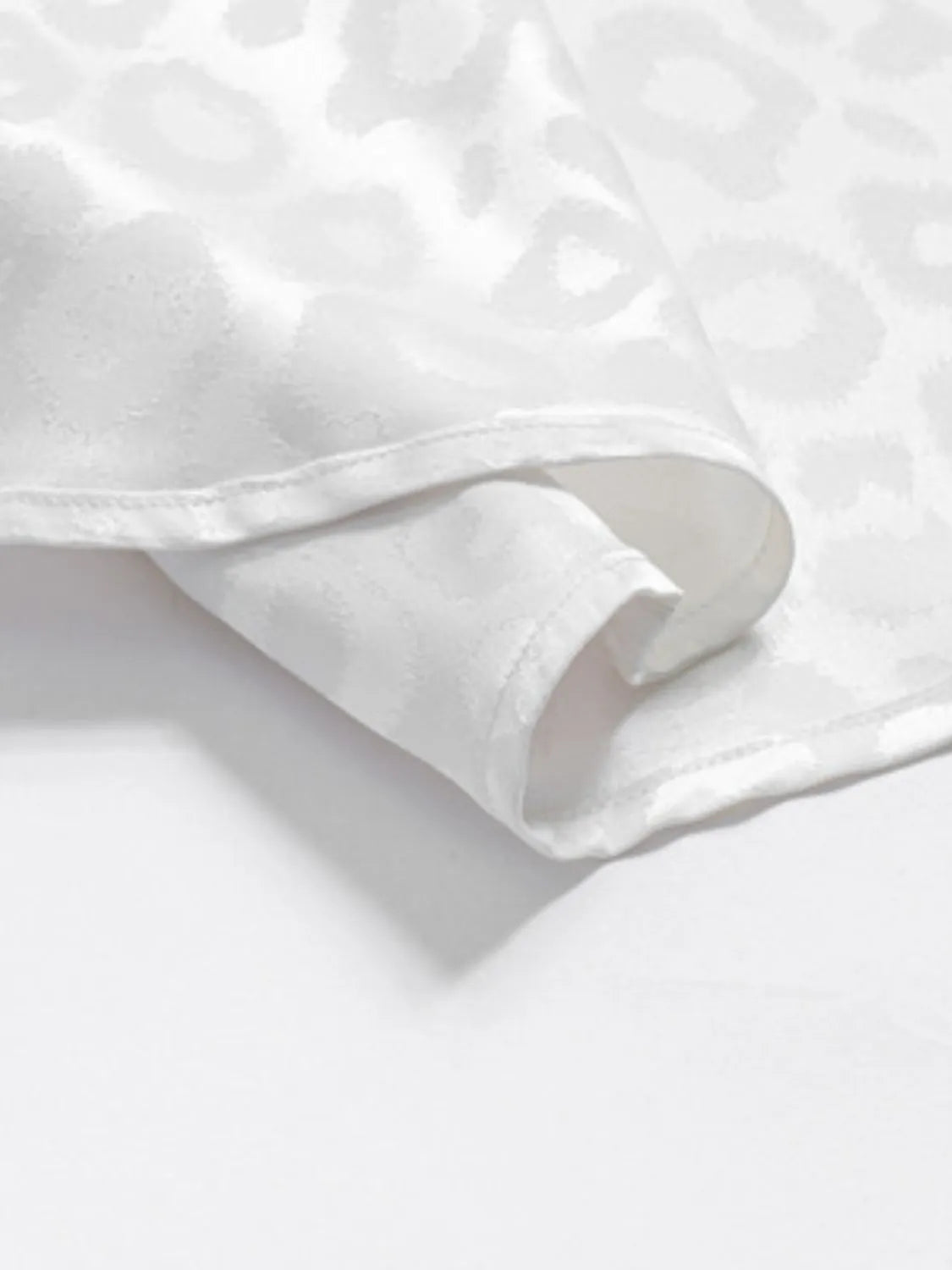 Detailed Close-up of a White Leopard pattern Button Down Satin Shirt  