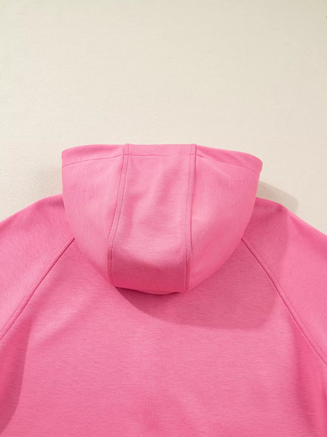 Close-up of a pink hoodie on a light beige background