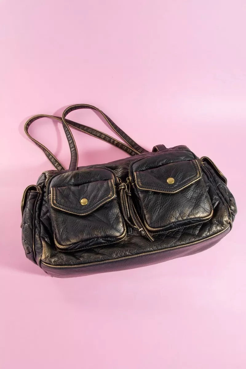 Vintage black leather handbag on a pink background