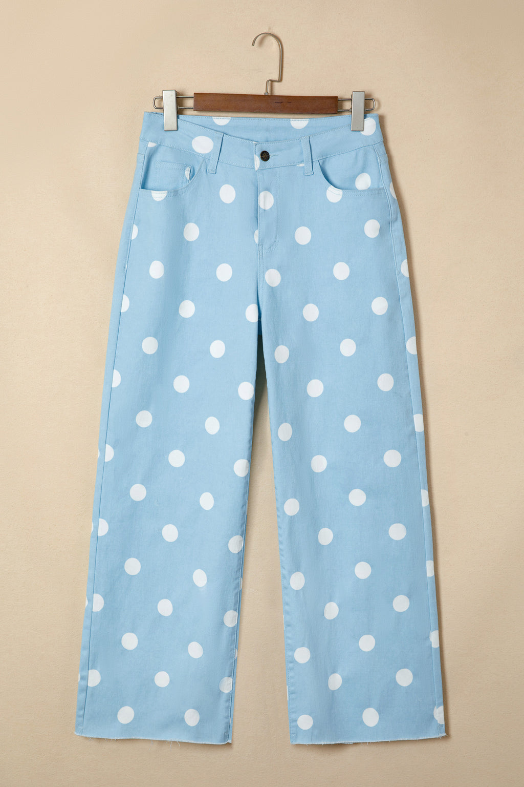 Light blue pants with white polka dots on a beige background front