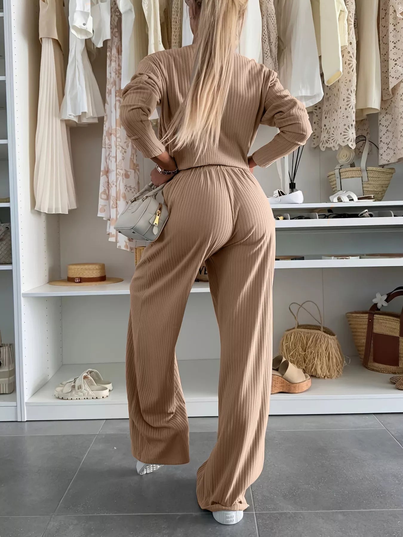 Person wearing a beige outfit standing in a clothing store.