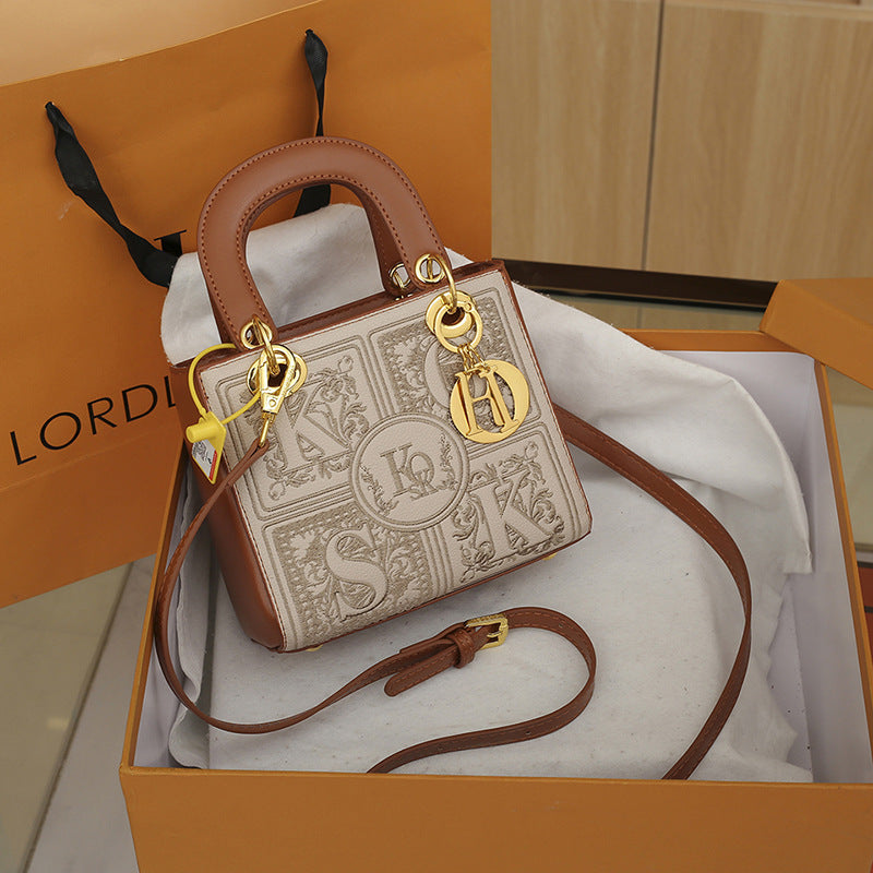 Designer handbag with gold hardware on a matching box