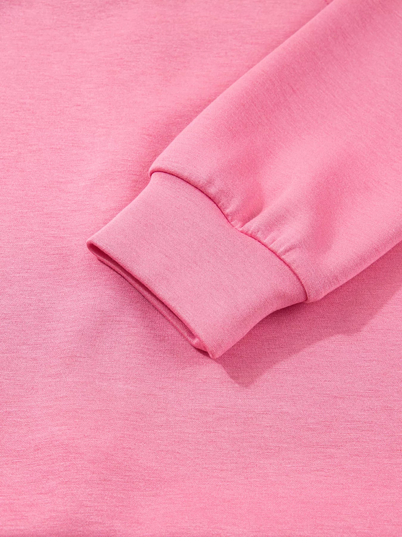 Close-up of a pink fabric with a rolled-up sleeve