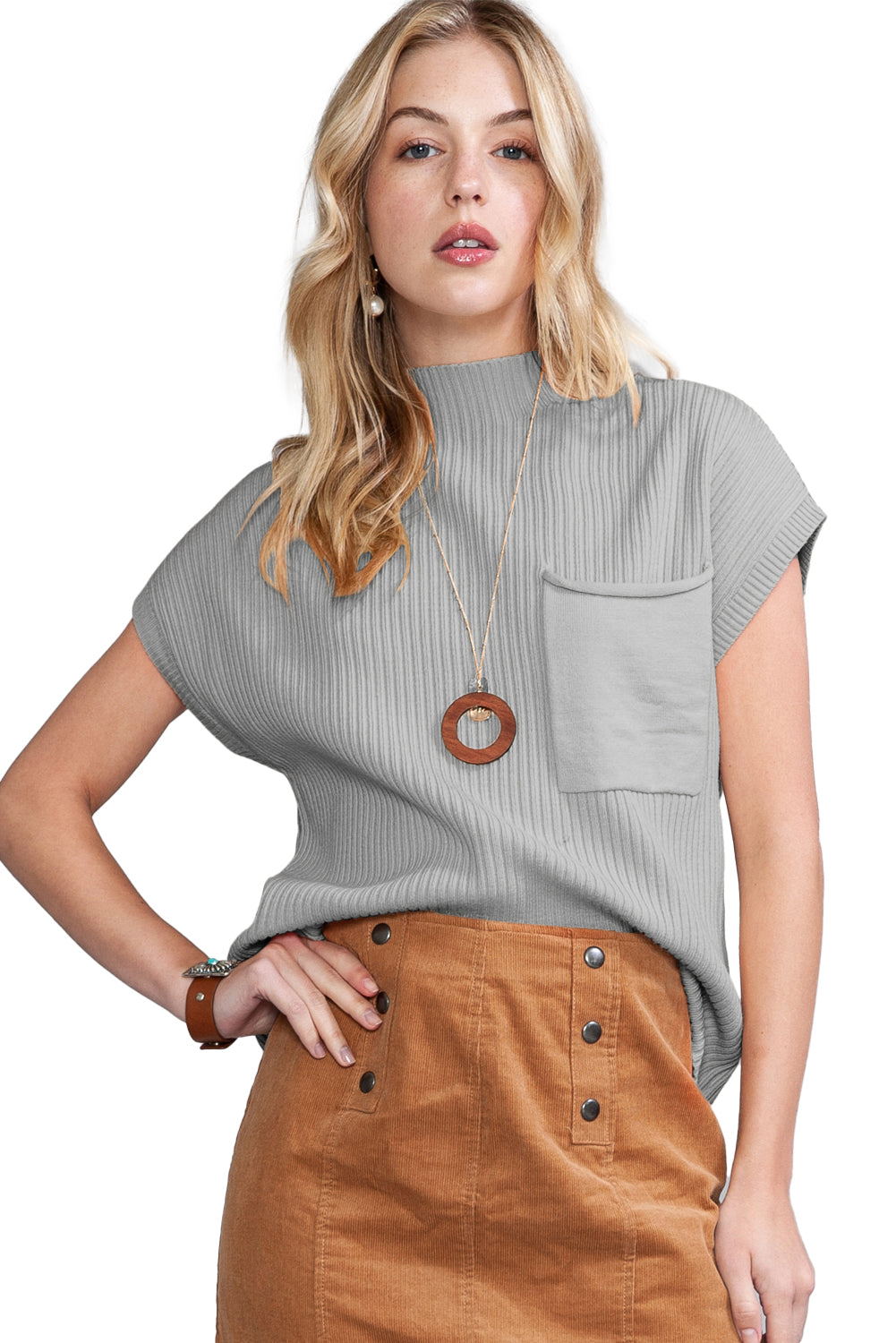 Woman wearing a gray ribbed top with a pocket and brown skirt on a white background
