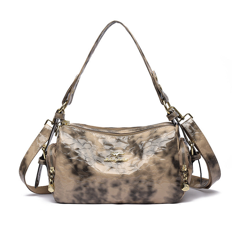 Designer handbag with a camouflage pattern on a white background