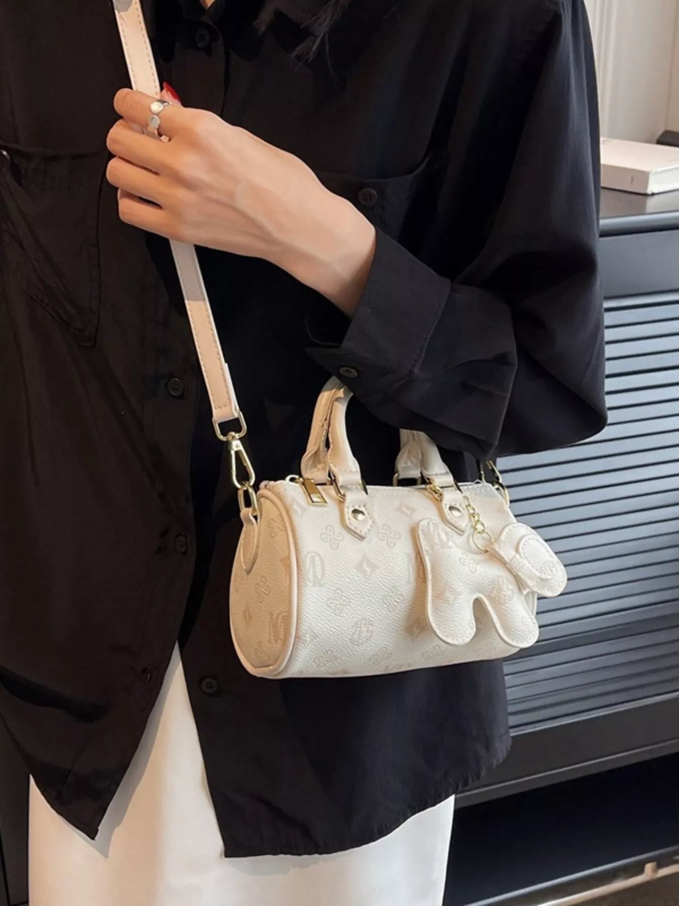 Person holding a white handbag with beige accents