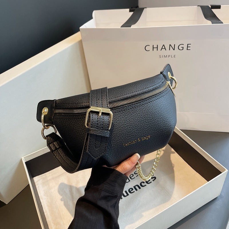 Black leather waist bag held in front of a 'CHANGE' branded box.