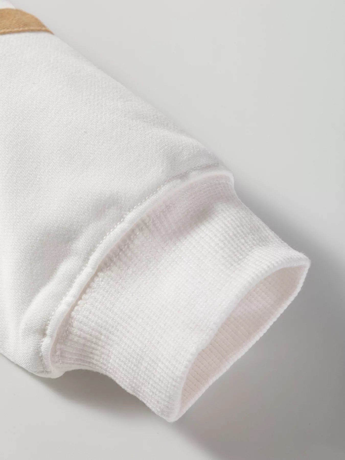 Close-up of a white sock with a beige toe on a light gray background