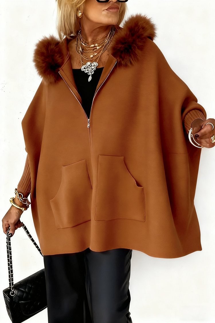 Brown poncho with fur trim worn by a person on a white background