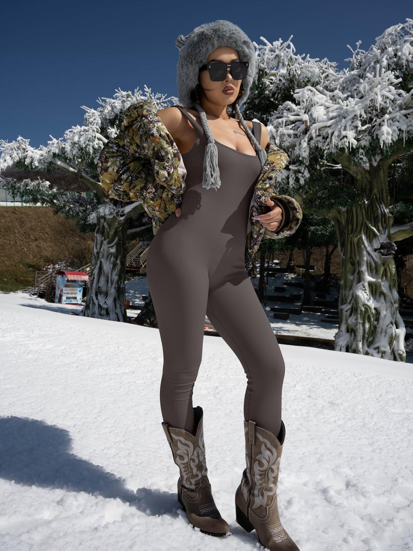 Person in a brown outfit with fur-lined hood and boots standing in the snow.