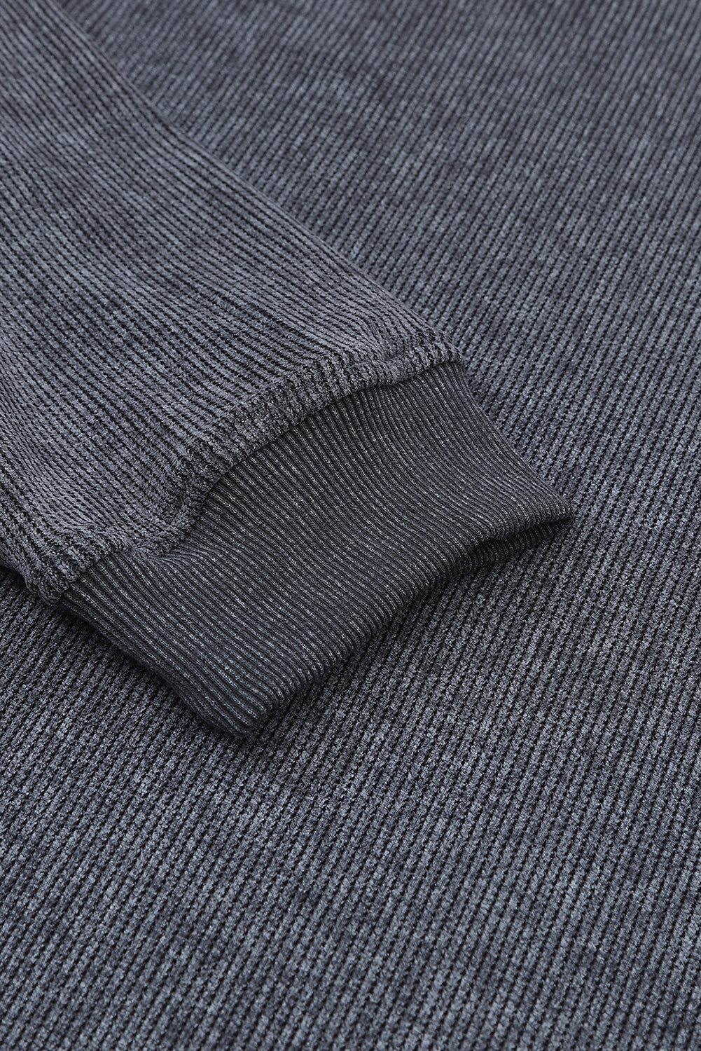 Close-up of a textured gray sweater with a focus on the collar and sleeve.